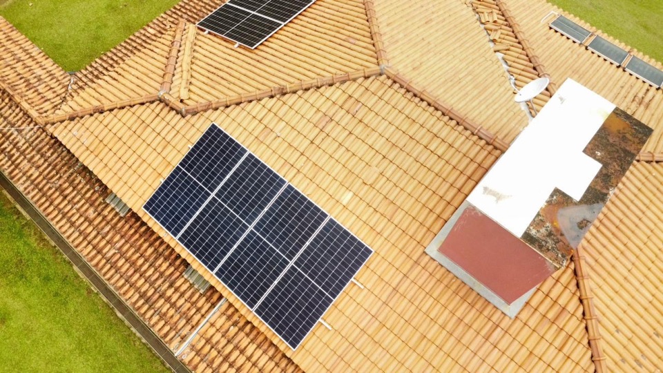 Placas solares sobre telhado cerâmico de uma casa, vista de drone